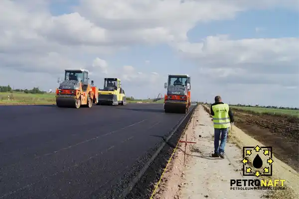 Workers are working on the road construction project with the help of penetration bitumen.