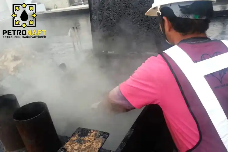 Workers utilizing oxidized bitumen in waterproofing process on a roof.